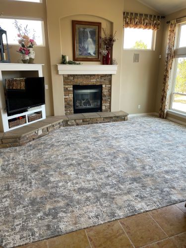 Neutral area rug in living room with tile floor